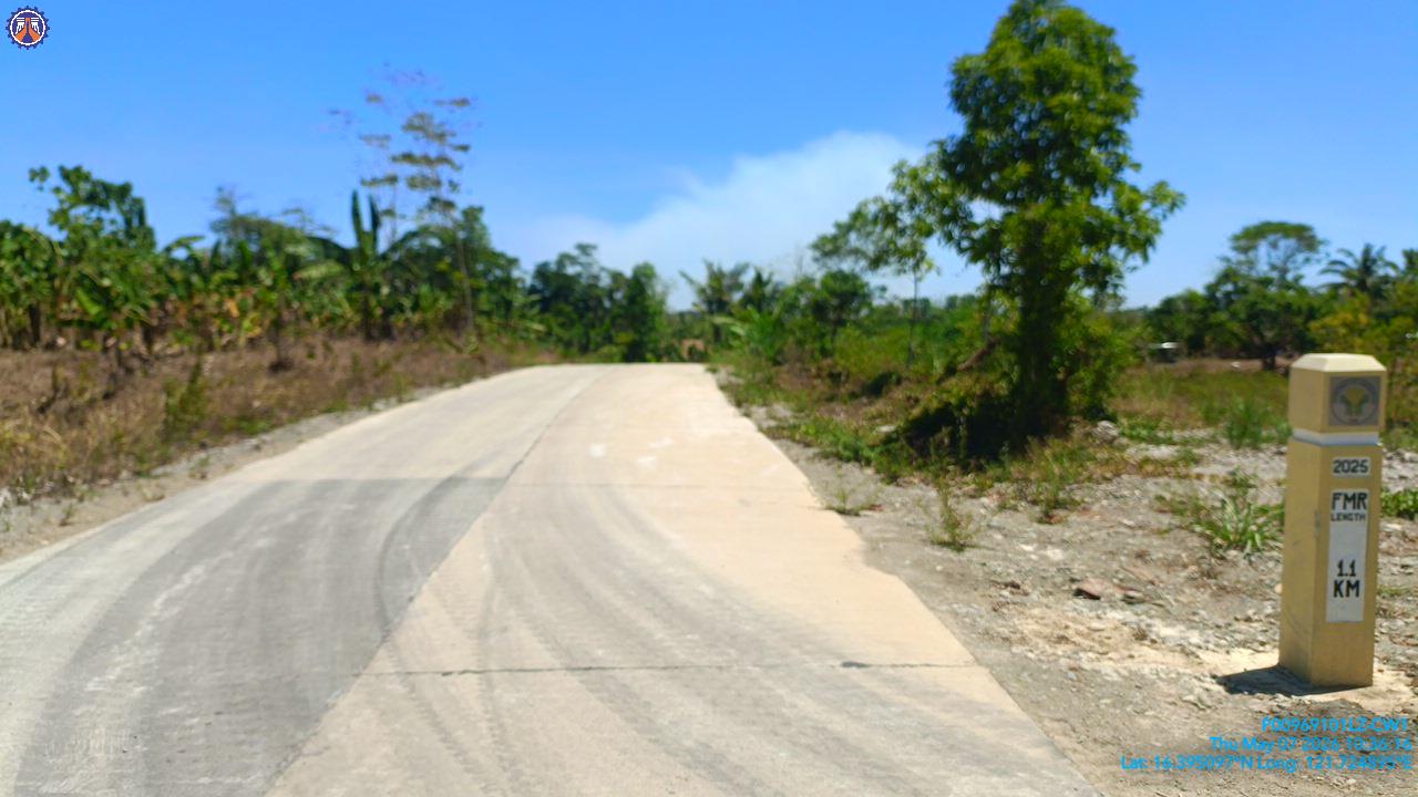 Completed concrete farm-to-market road lane with a DPWH project marker